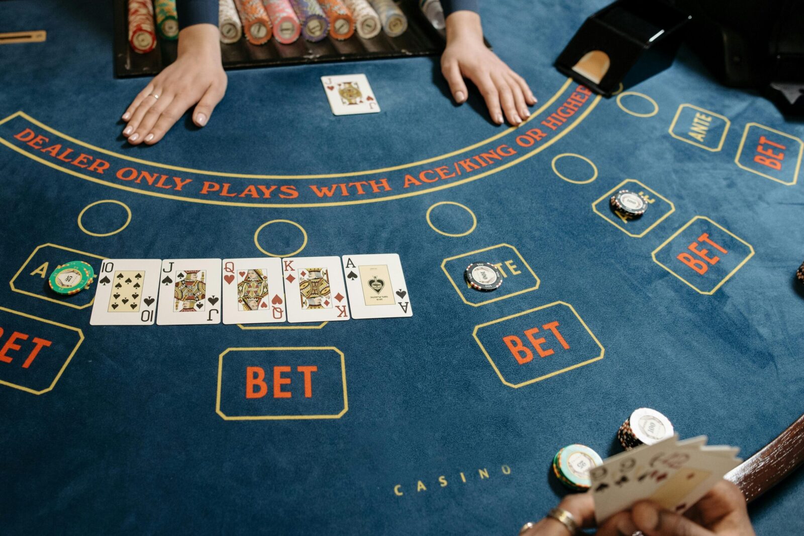 A casino gaming table featuring poker cards and chips, showcasing a vibrant gambling scene.
